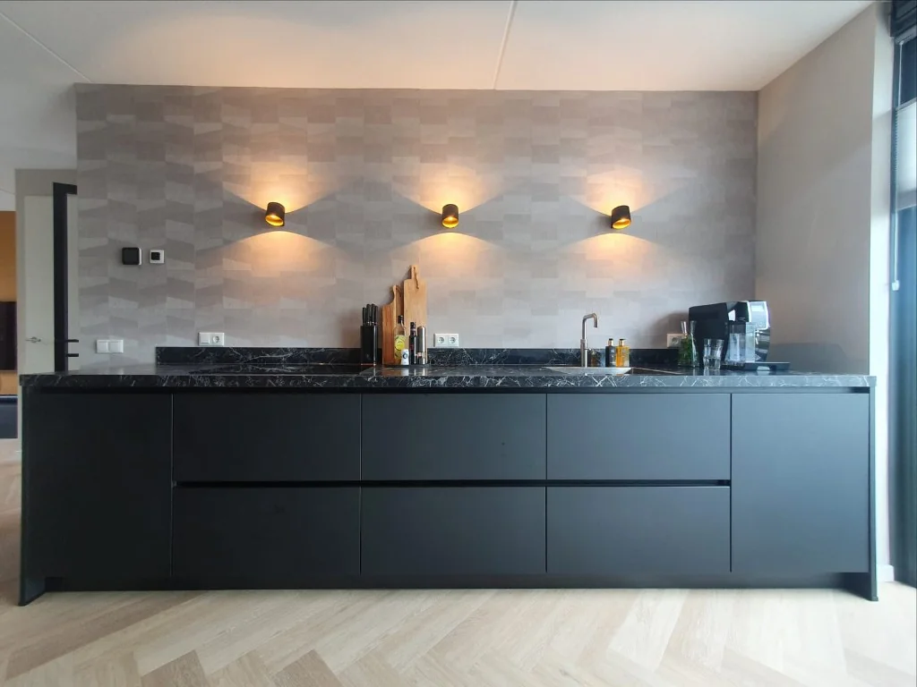 Donker keukeneiland tegen patroonwand